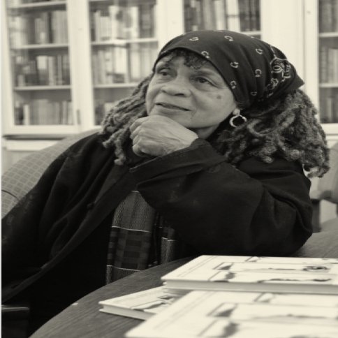 Sister Sonia Sanchez black and white photo in headwrap in the library 