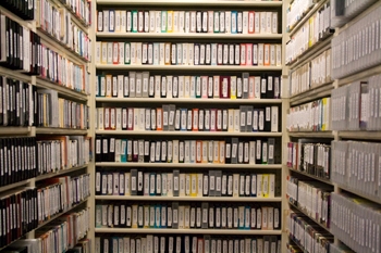 U-shaped shelves with rows of media tapes stacked from floor to ceiling.