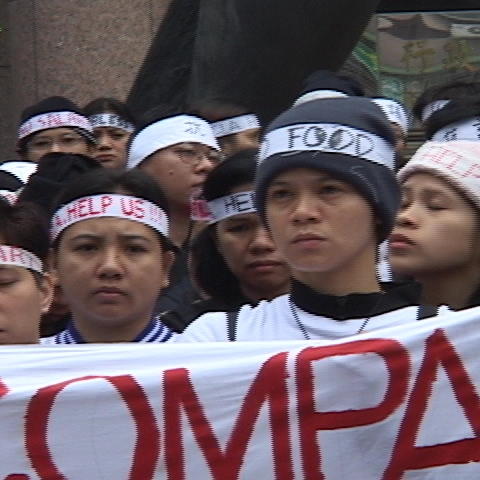 Women holding up a sign that reads "COMPAN" 