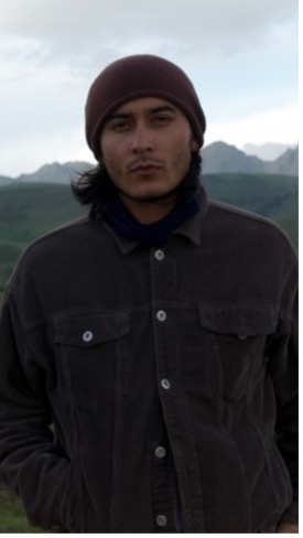 Medium shot of a man wearing a wool cap and dark jacket.