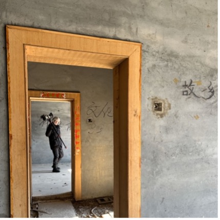 A man standing in the background of two door frames.