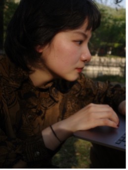 Woman with short hair looking at a keyboard.