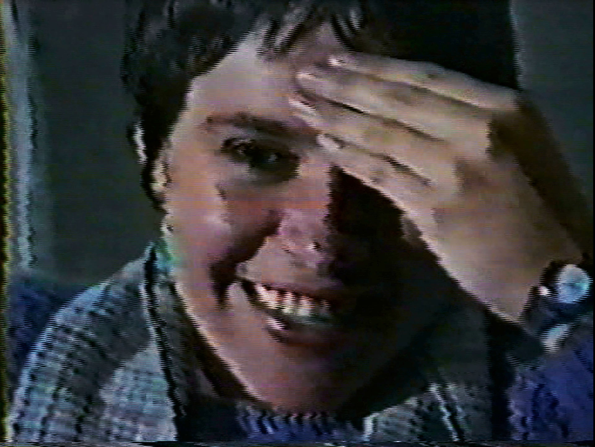 An image of a child smiling with a hand covering one eye.