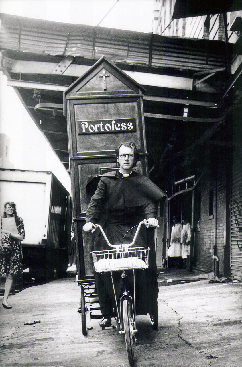 Joey Skaggs pedaling Portofess, his mobile confessional booth, on his way to the Democratic National Convention in 1992 to hear the confessions of politicians, courtesy of The Joey Skaggs Collection.