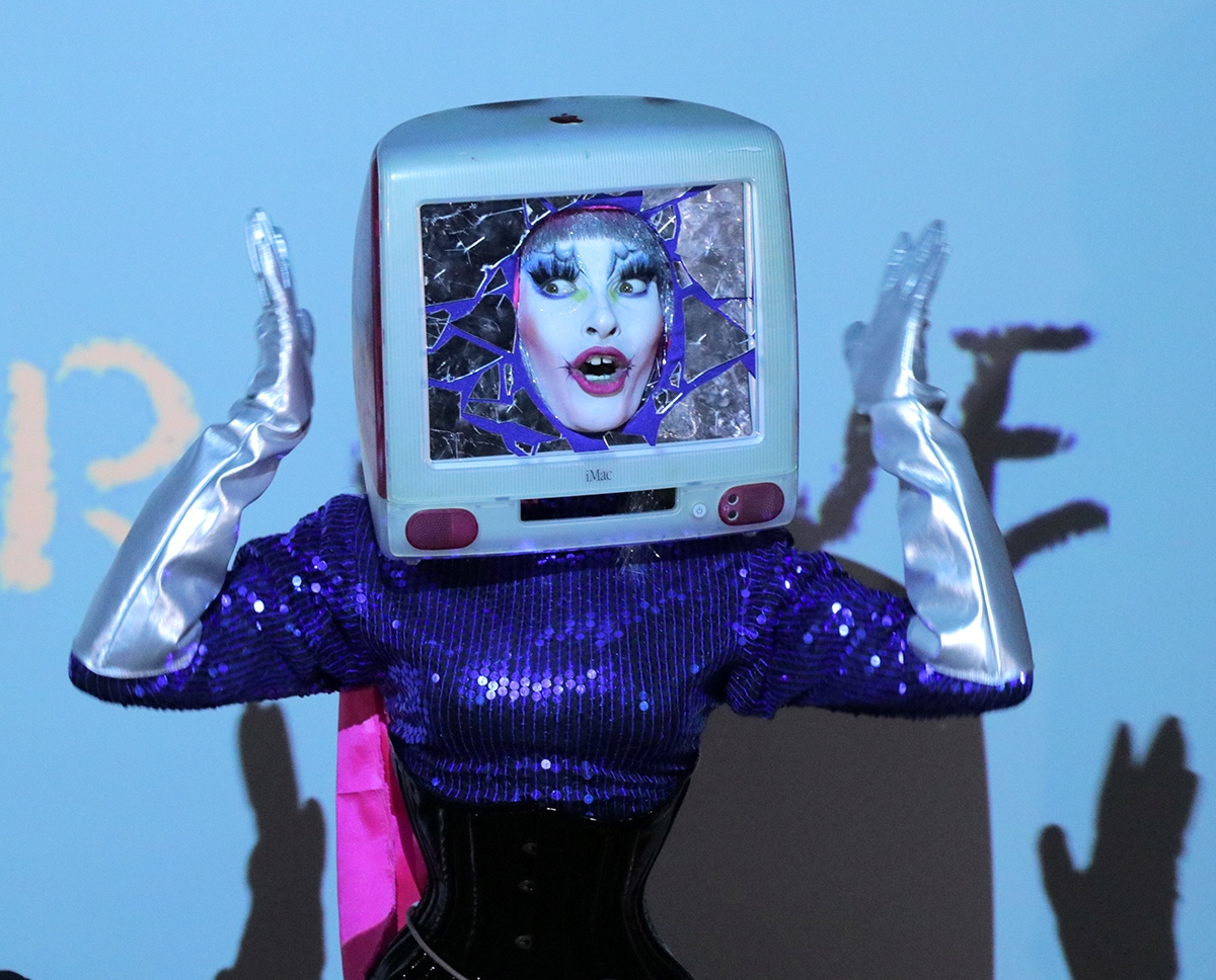 Student gives a drag performance wearing a computer monitor