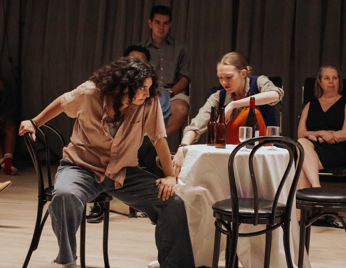 two students perform a scene set at a dining table
