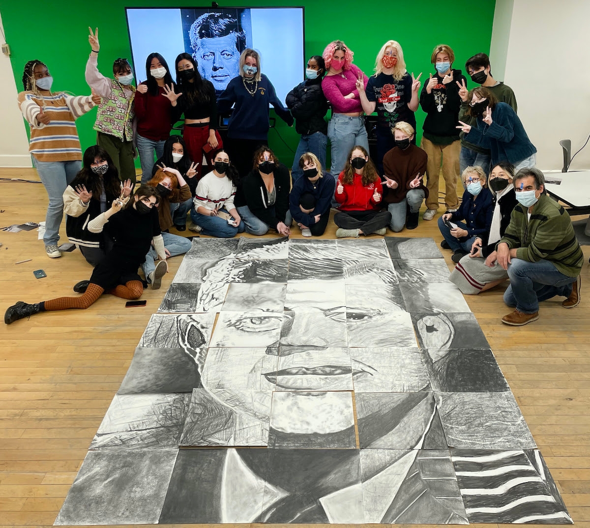 Students gathered around a collaborative drawing of JFK
