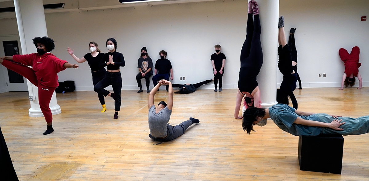 Students in a large studio space engaging in movement performance