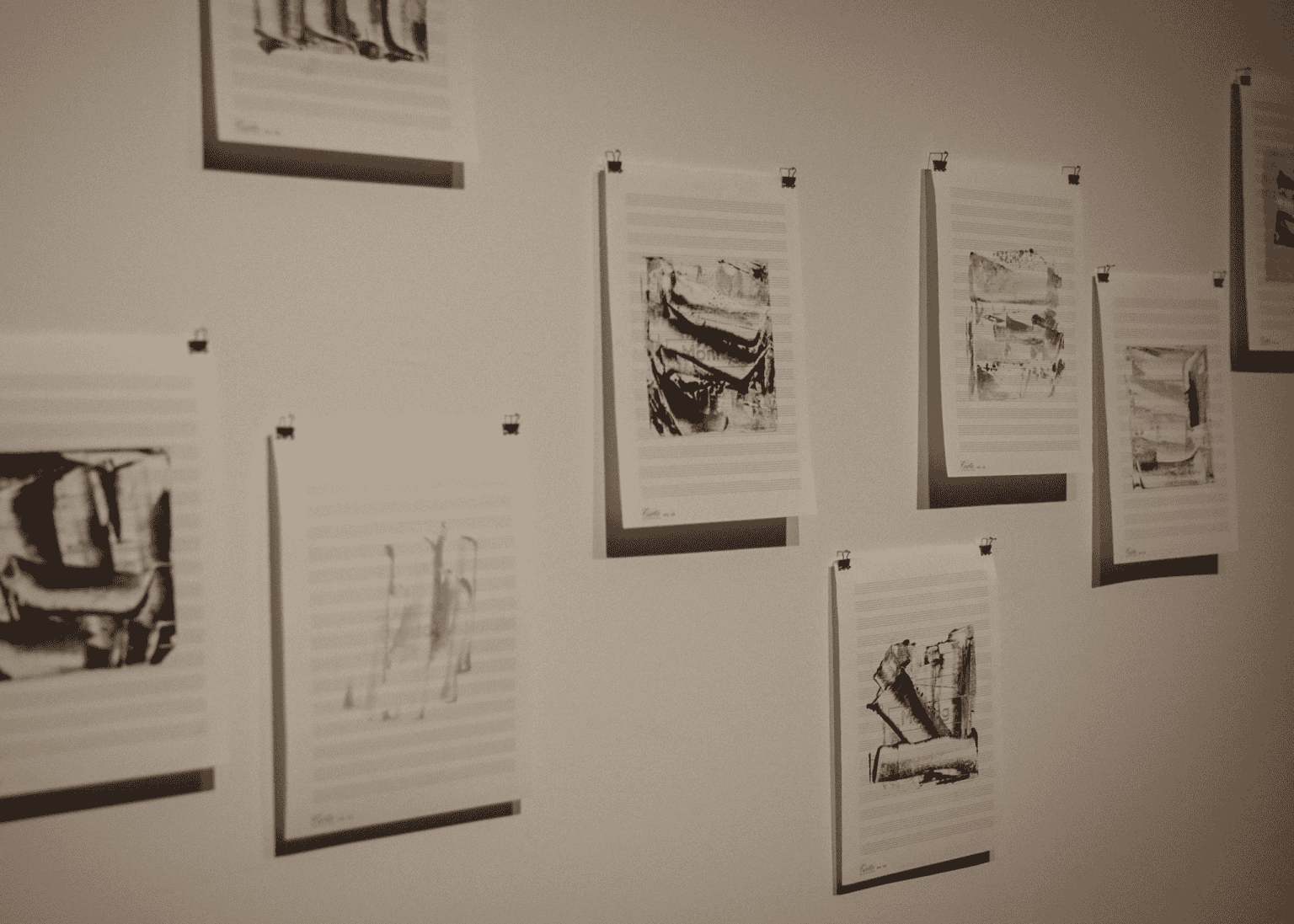Hand printed composition on music sheets are pinned to a wall