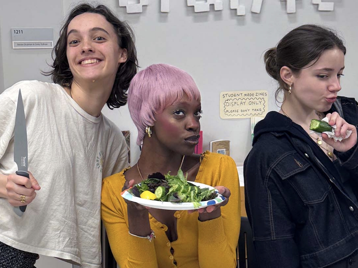 Students sitting making salad