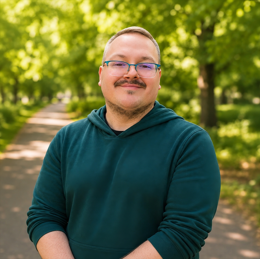 Kevin Hunter smiles at camera on green and orange background