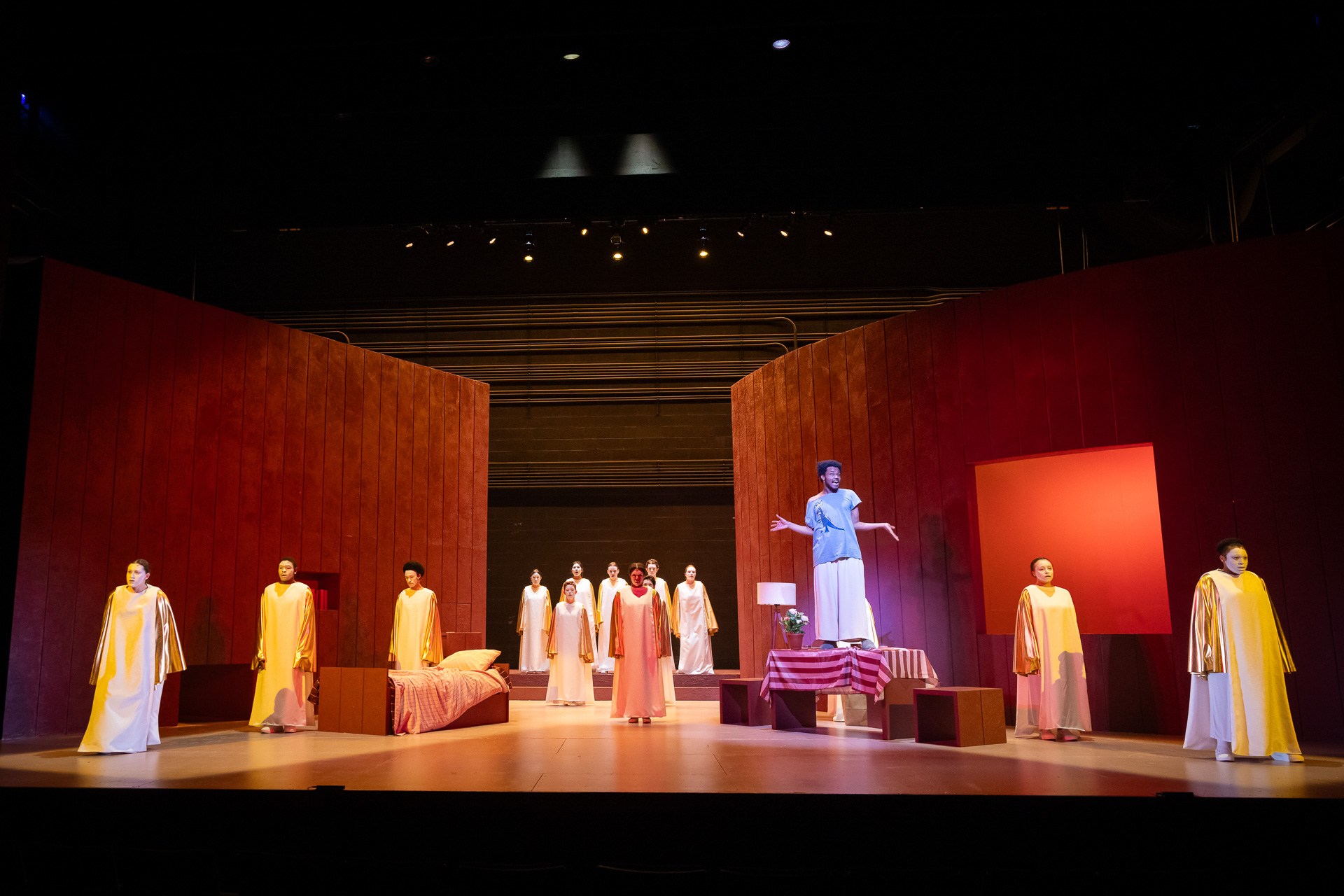 people in robes on stage with a man person on a table speaking