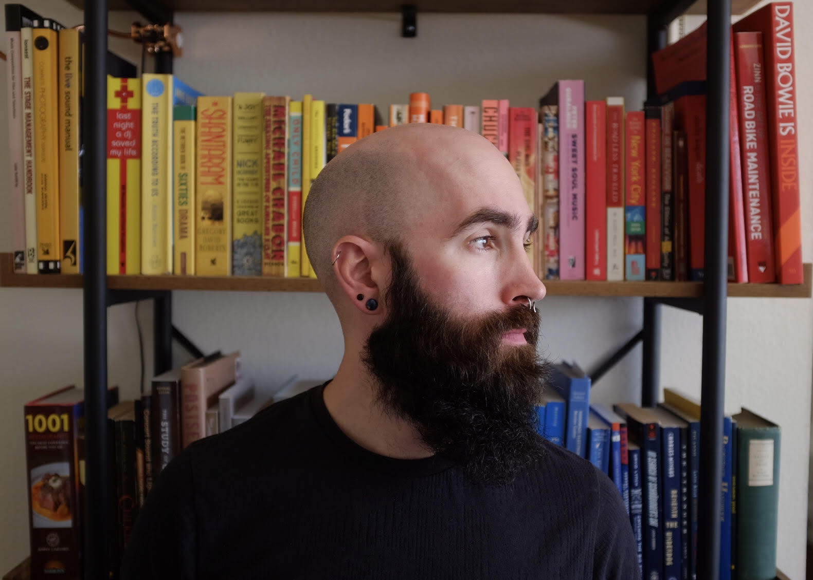 side profile image of Alex Hawthorn with shelves of books behind them