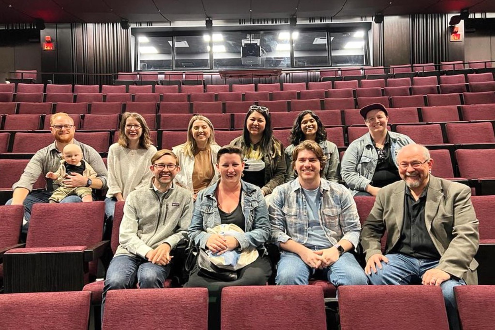 Production & Design Studio alumni sitting in the audience seating inside the Iris Cantor Theater