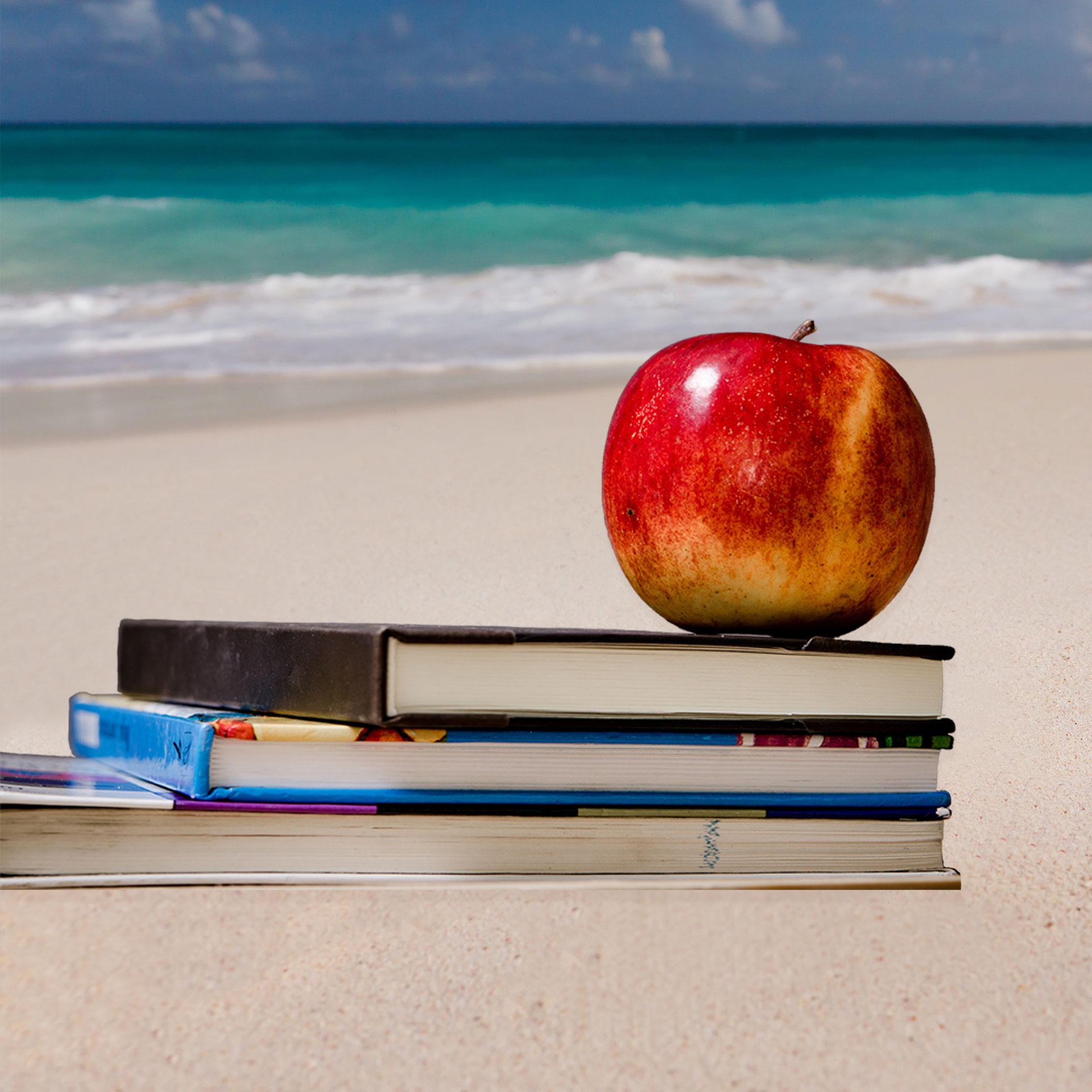 Apple and Books on a Beach