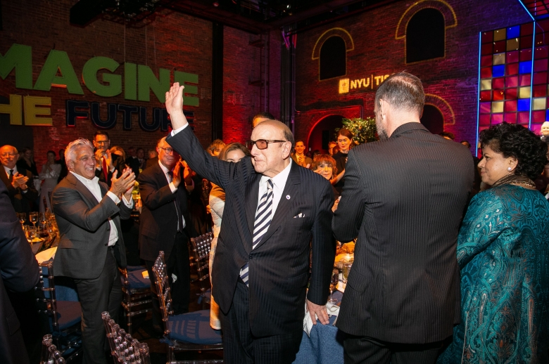 Clive Davis in a suit waving at guests at the 2019 Tisch Gala