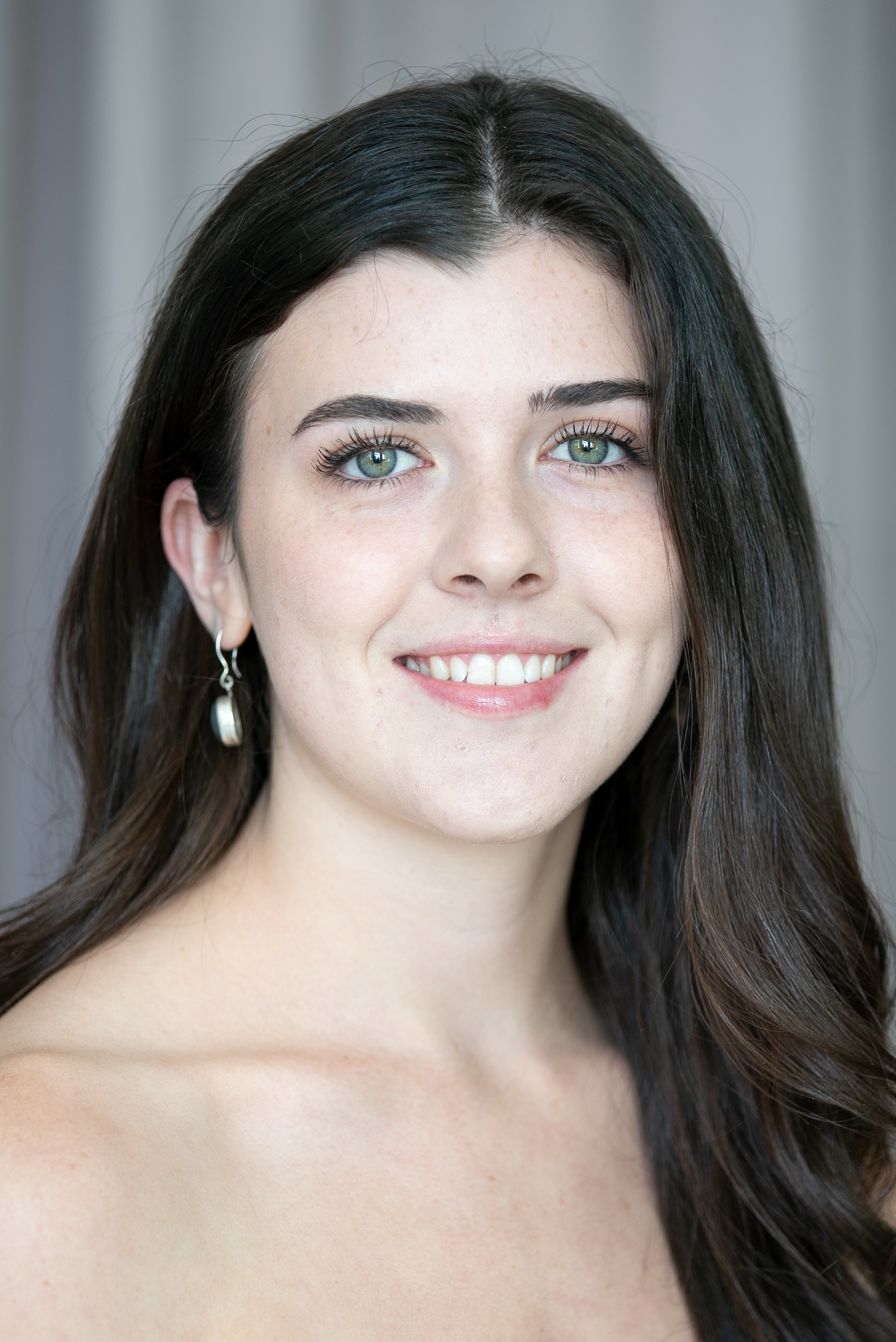 smiling student with bright eyes and dark brown hair