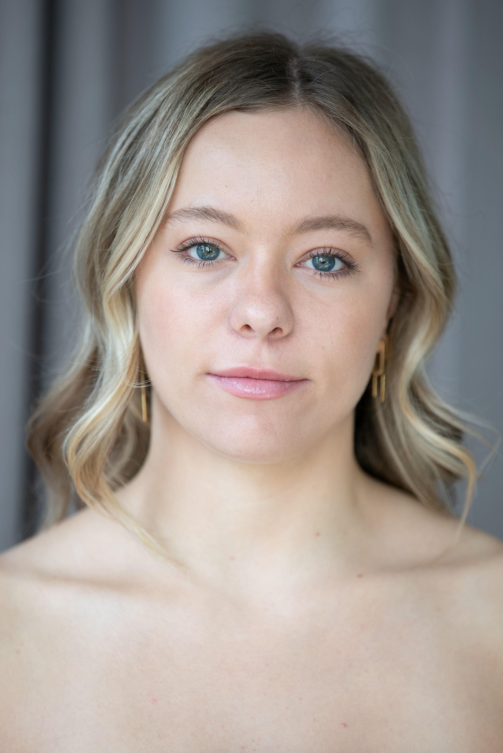 blonde student with shoulder length hair looks directly into the camera. 