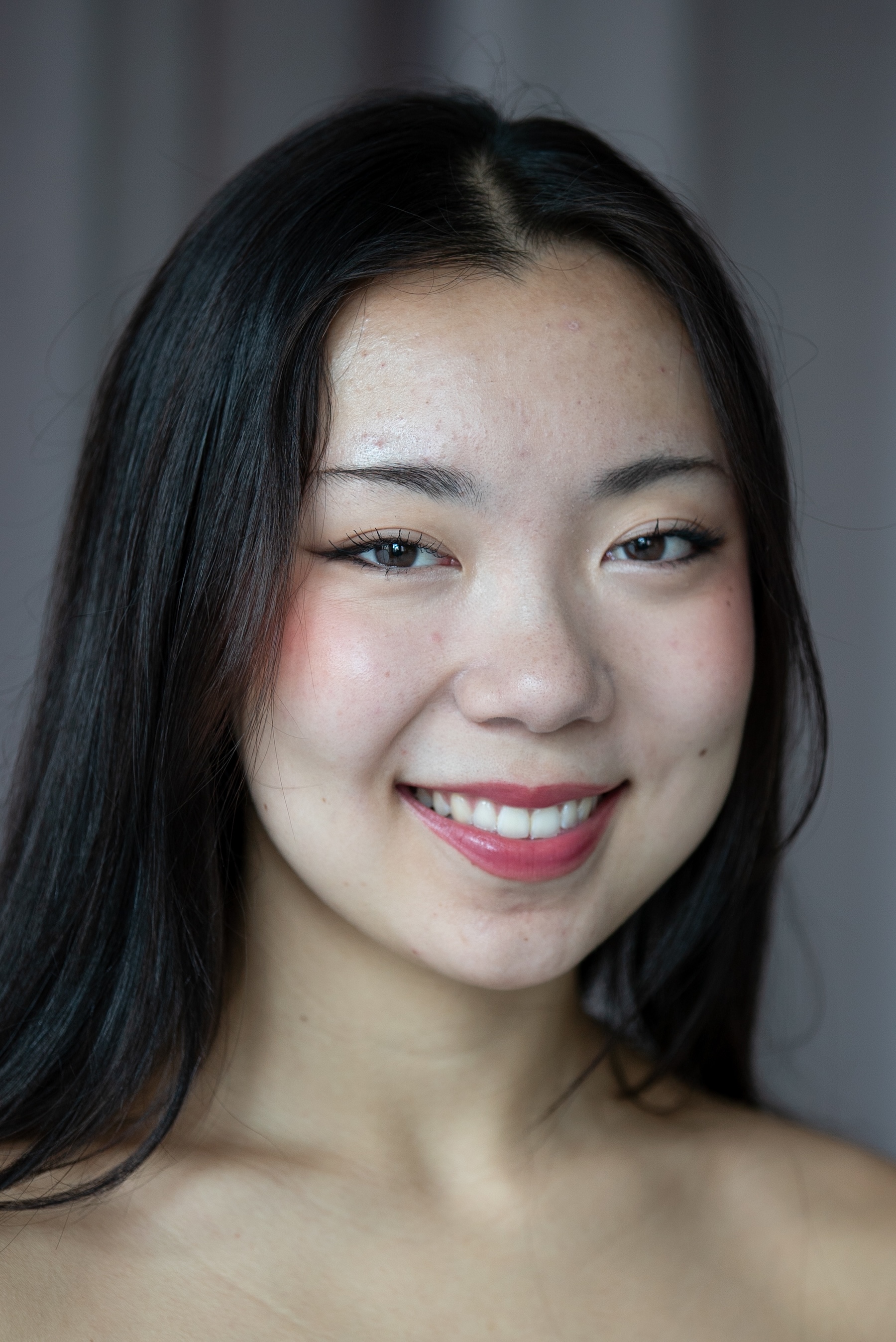 smiling student with dark hair past the shoulders. 