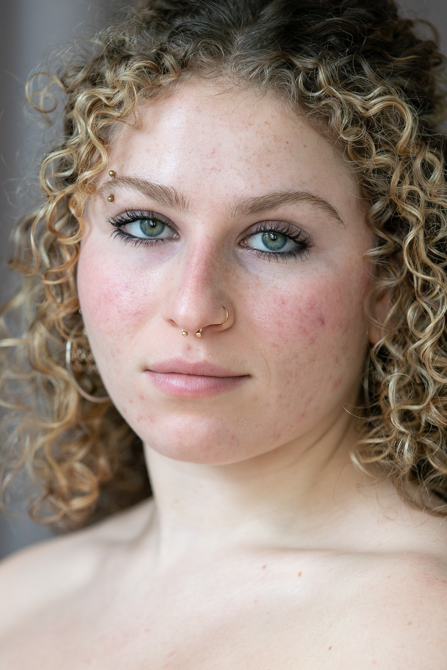 student with blue eyes and blonde hair stares into the camera. 