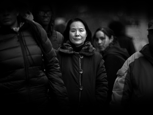 Film still from Kimchi Taco. Black and white photo of woman in a crowd. 