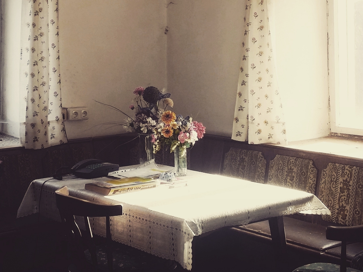 Film still from "Mami" sagte. Image of table with table cloth and flowers on it. 