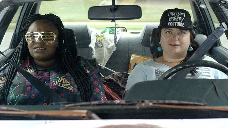 A closeup of two young women driving a car.