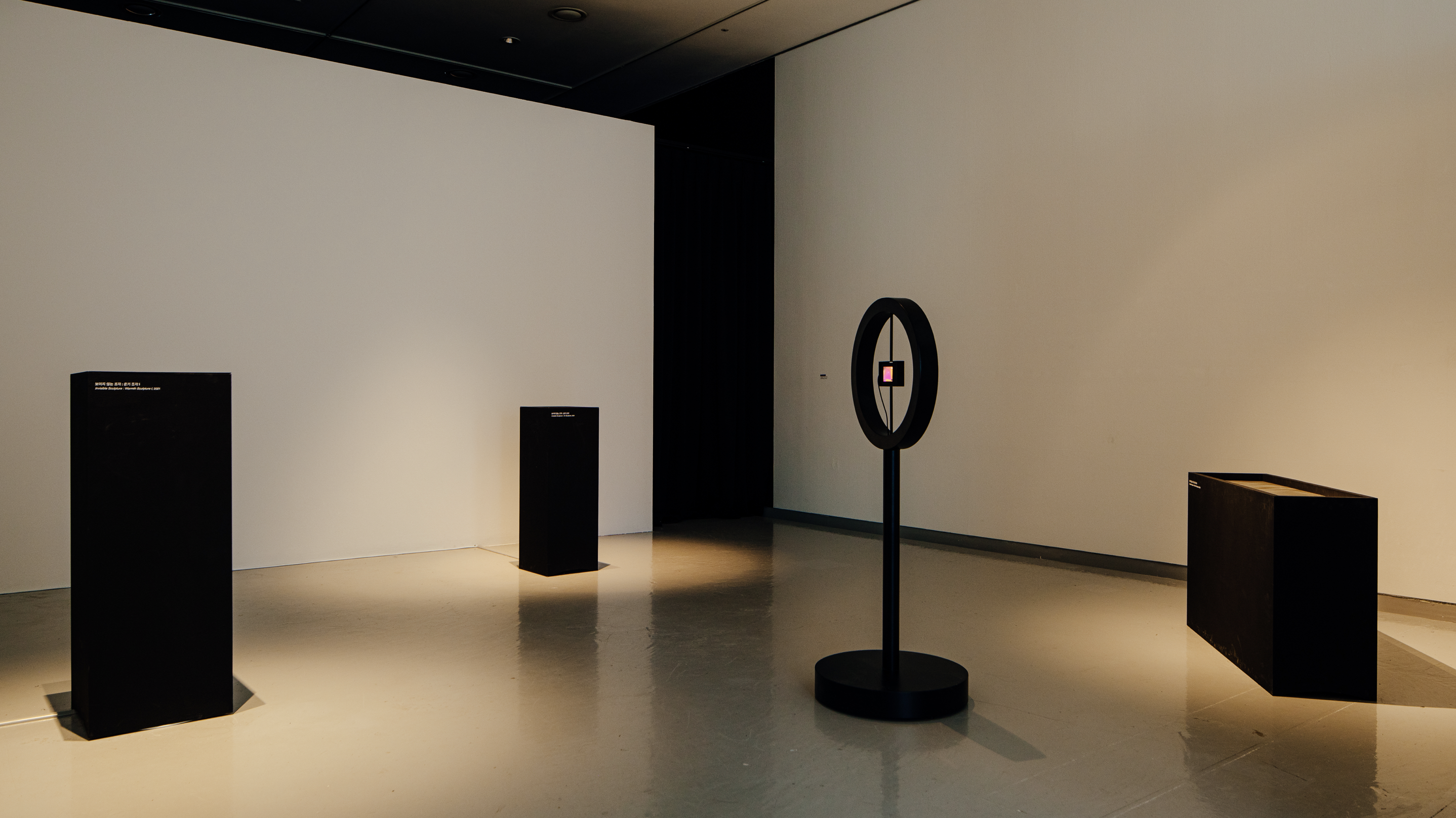 3 black podiums in an exhibition space