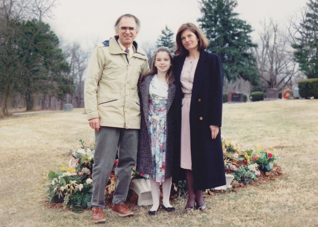 Image of a family in front of a burial plot.