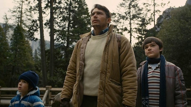 A image of a man (James Franco) with two young boys in a wooden area.
