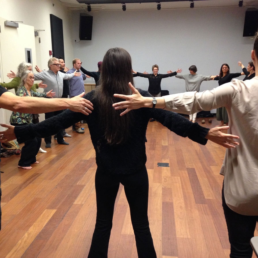 Artists standing arm to arm in a circle