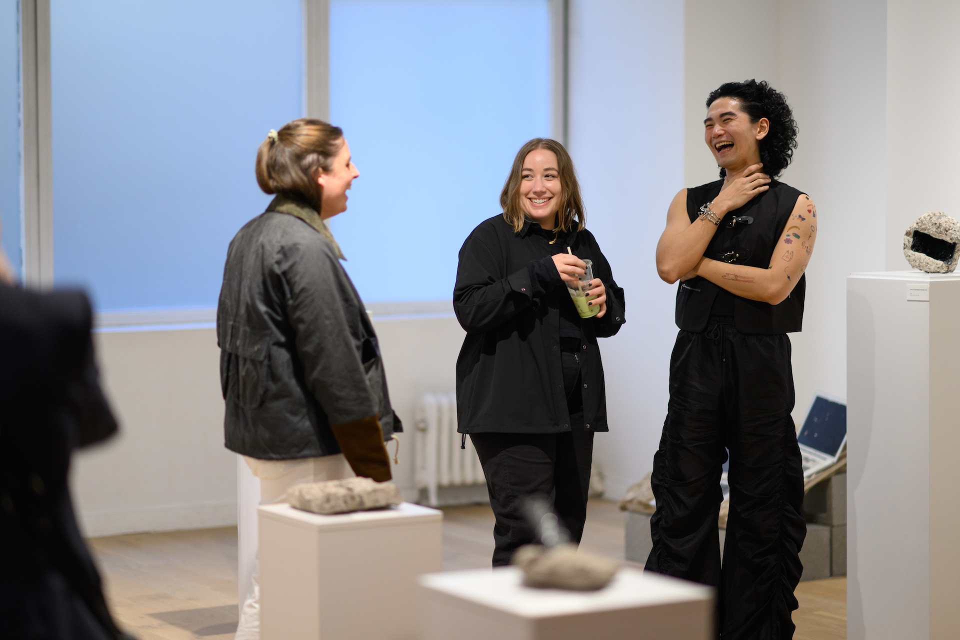 Blair Simmons and two guests standing in her new solo exhibition, “Archive of Digital Portraits Cast in Concrete”.