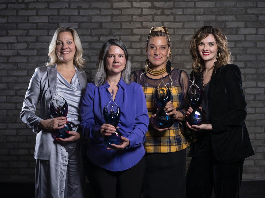 Four women holding awards.