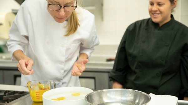 Students work in a kitchen with eggs
