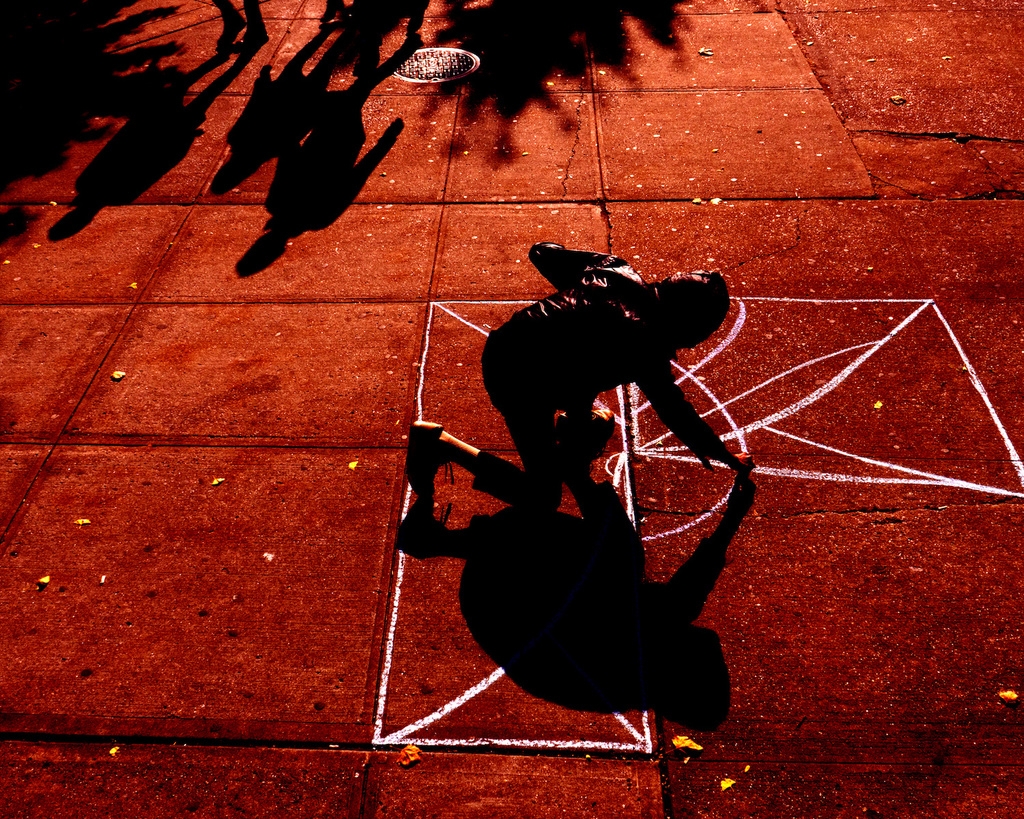 Man draws on ground with chalk