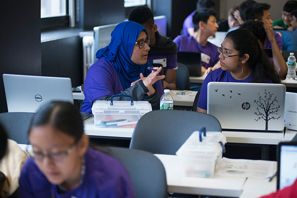 Students discussing/working at laptops