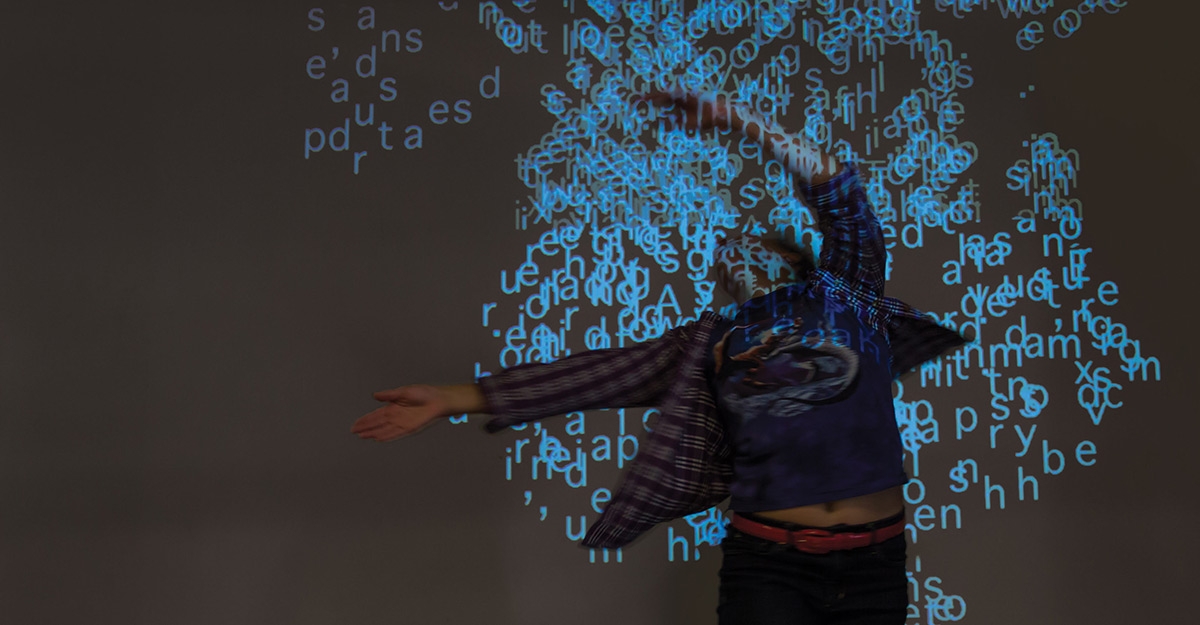 Image of a man interacting with reactive text based projections