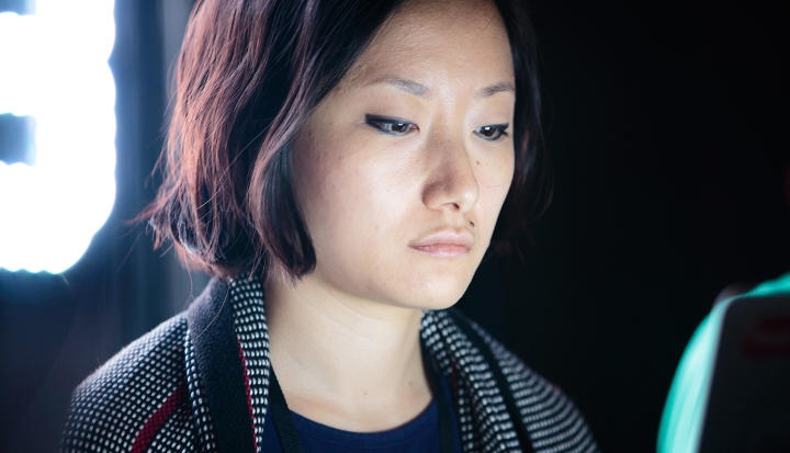 headshot of a woman with the glow of a laptop reflecting on her face