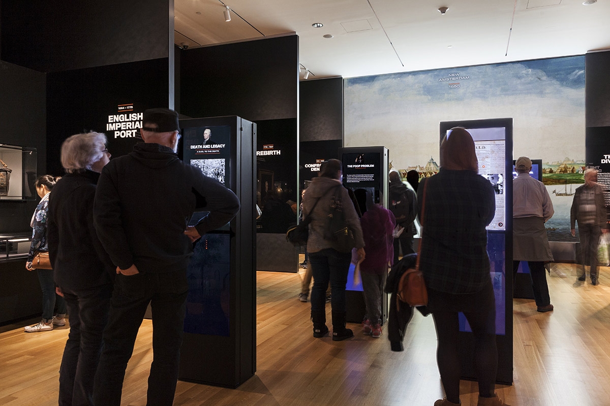 People interacting with screen based kiosks at the museum