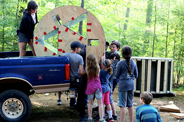 Children unloading truck with equipment in the outdoors