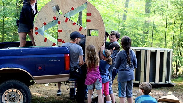 Children unloading truck with equipment in the outdoors