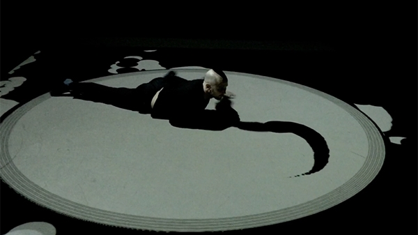 A person laying within a circle with a projected shape emanating out