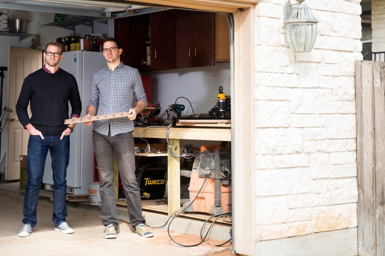 2 men standing in a workshop in a garage