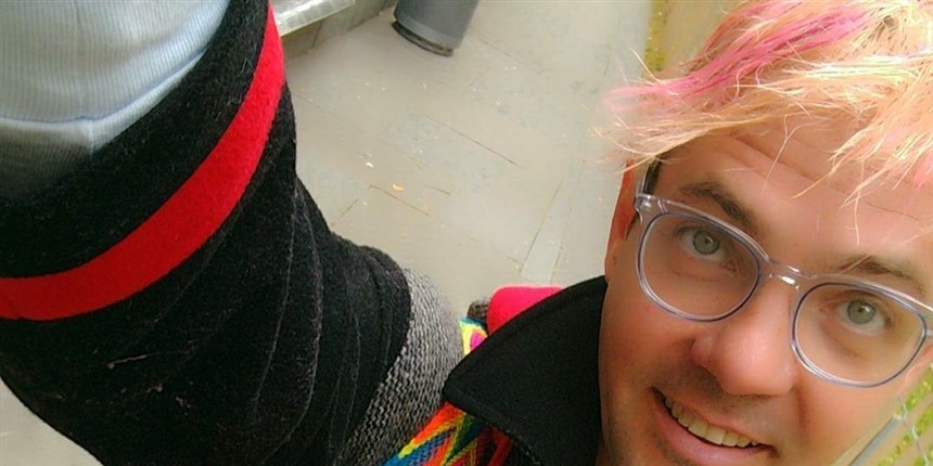 A selfie of a person wearing glasses and pink/blonde hair.