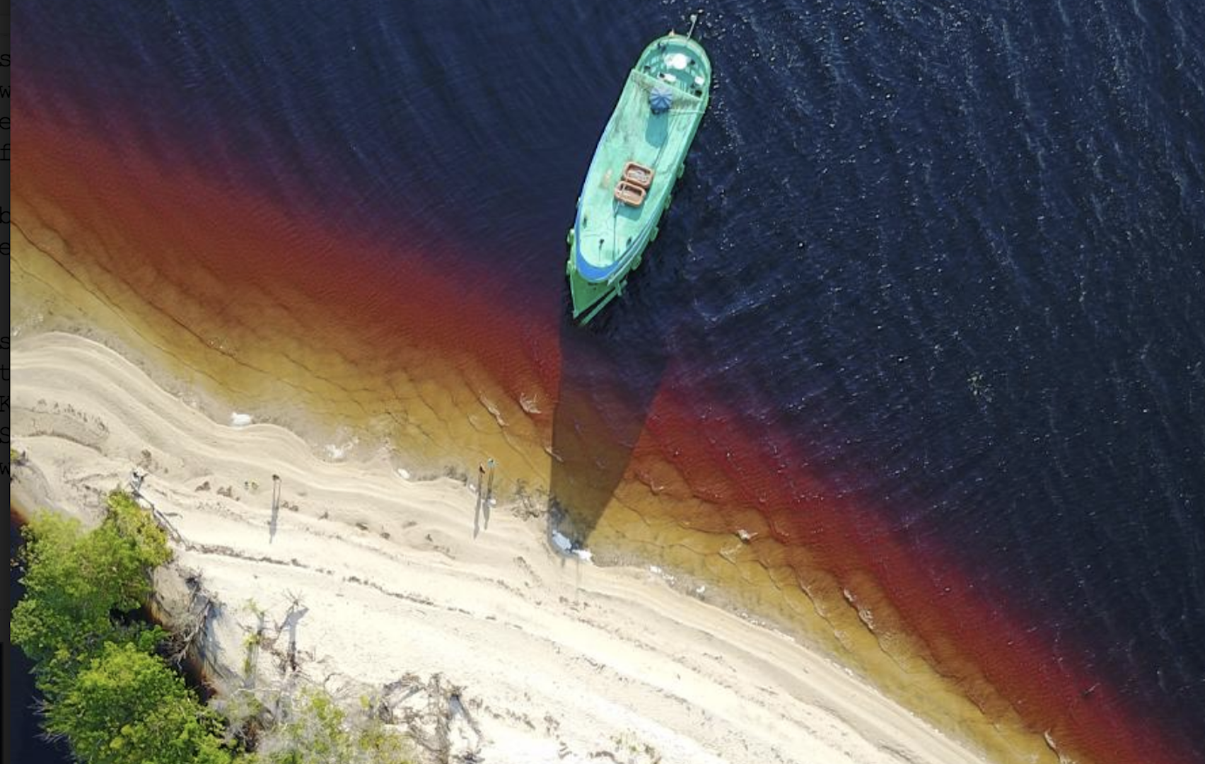 image of a blue boat approaching a dirty beach, taken from above