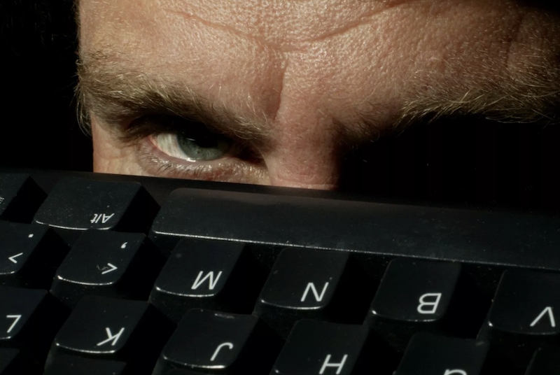 Creepy man looks over keyboard