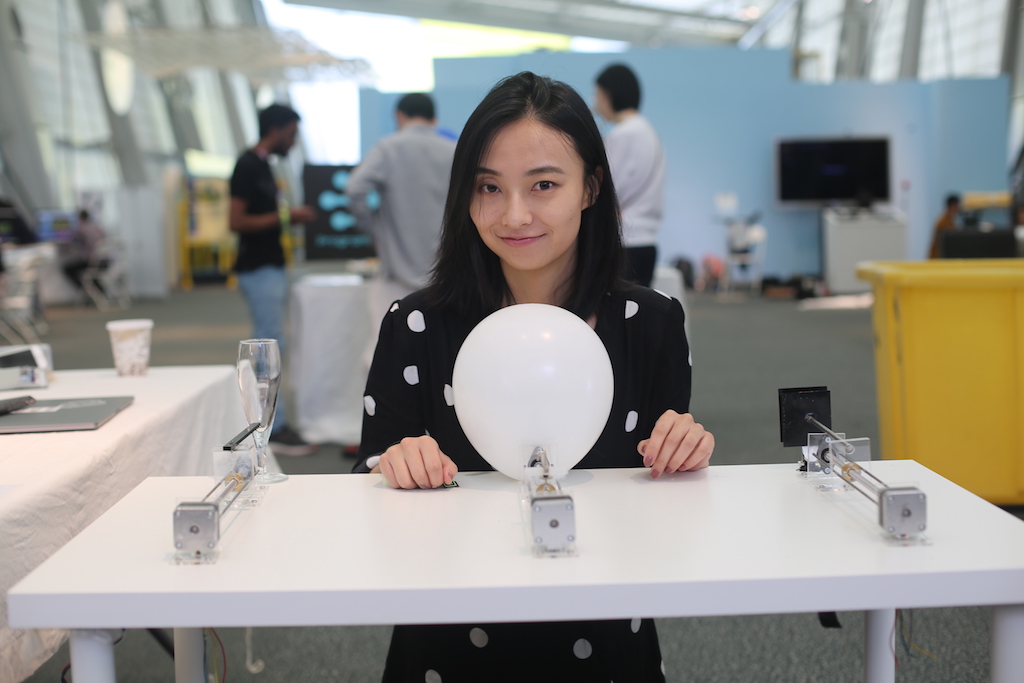 Student sits with project that is a small orb, similar to what fortune tellers use
