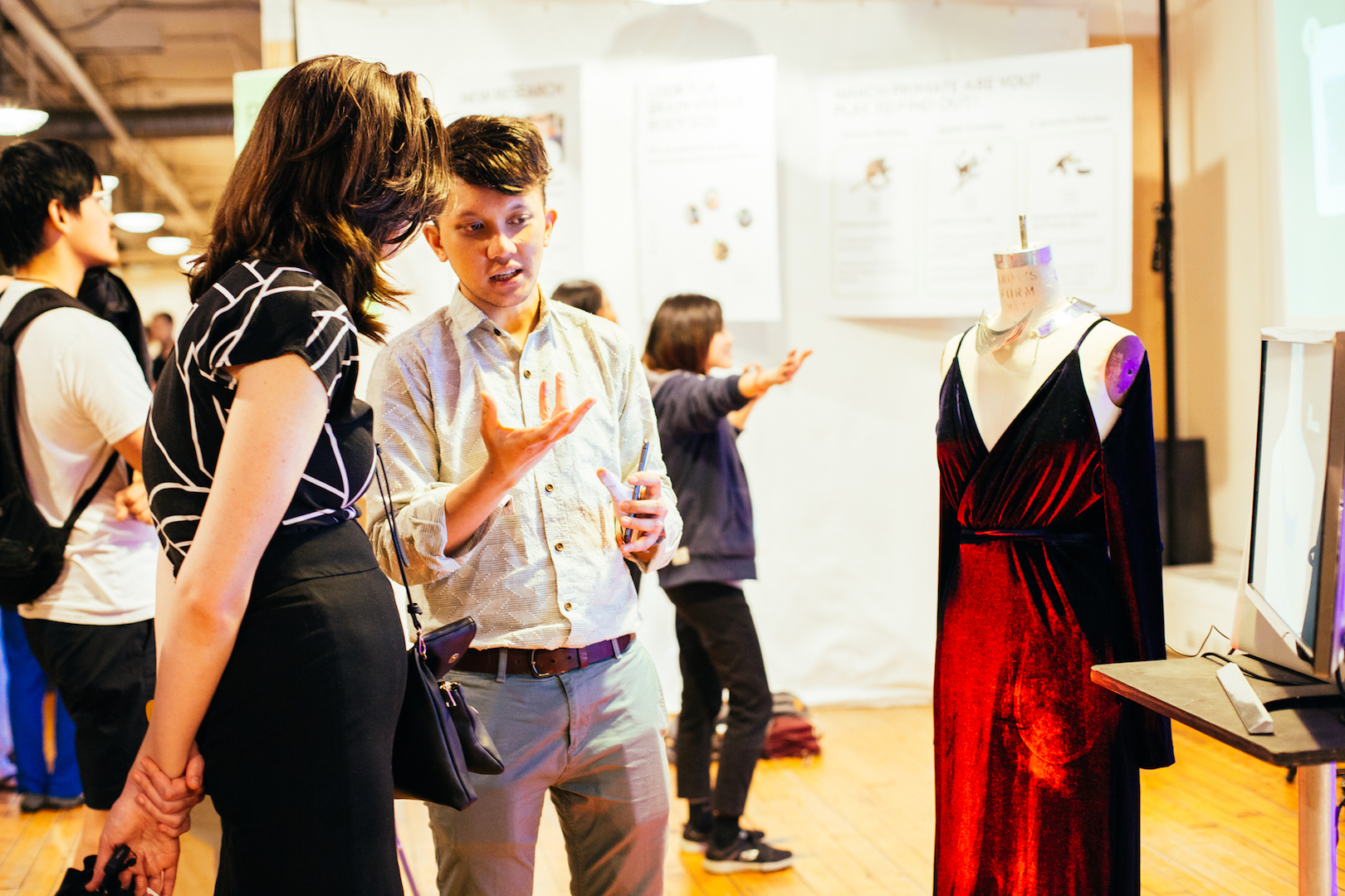 Student explains project of dress on mannequin to guest