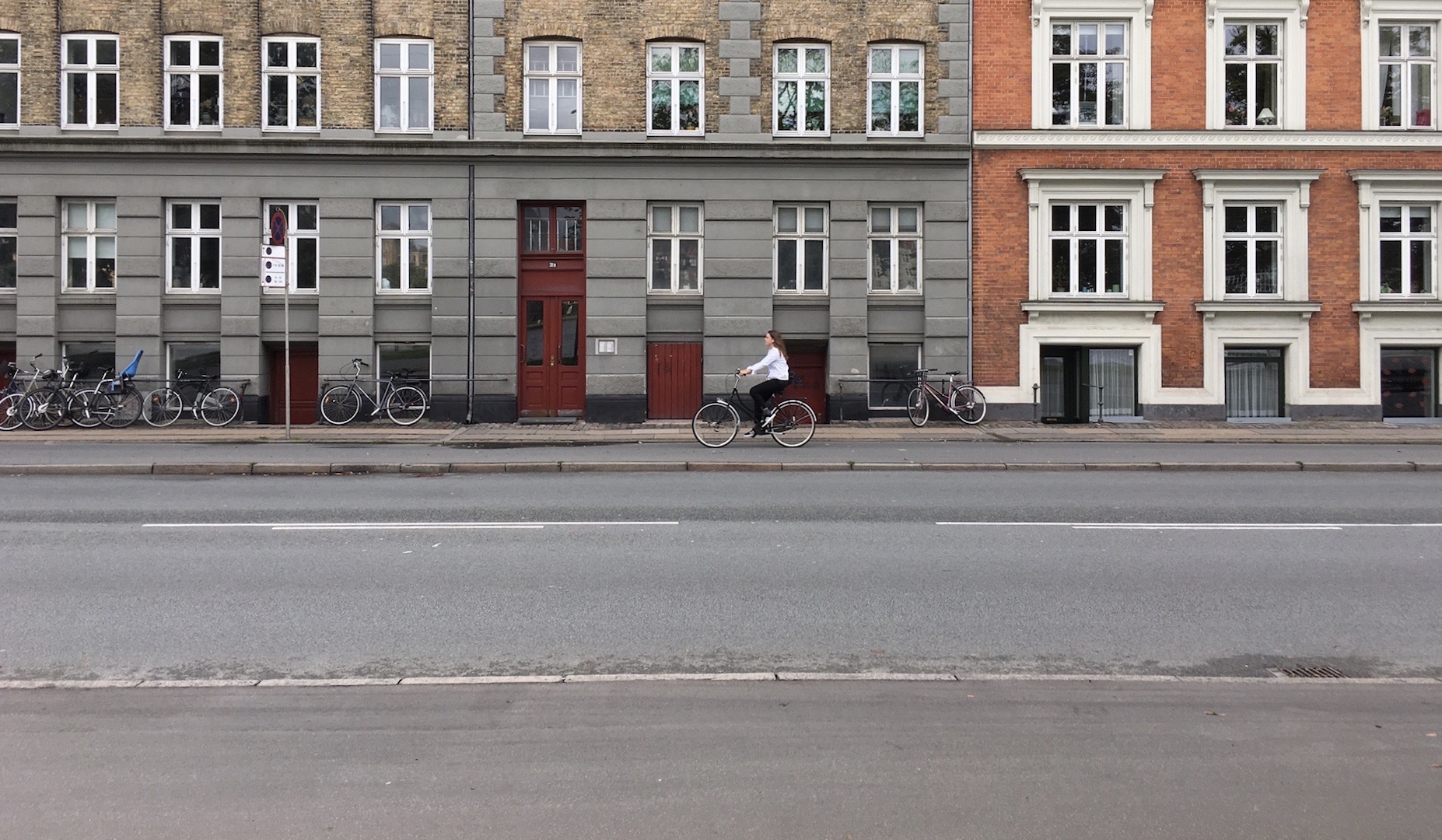 Woman rides her bike in a European looking city