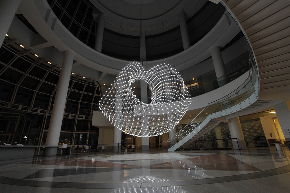 a light installation hanging in a large open lobby space